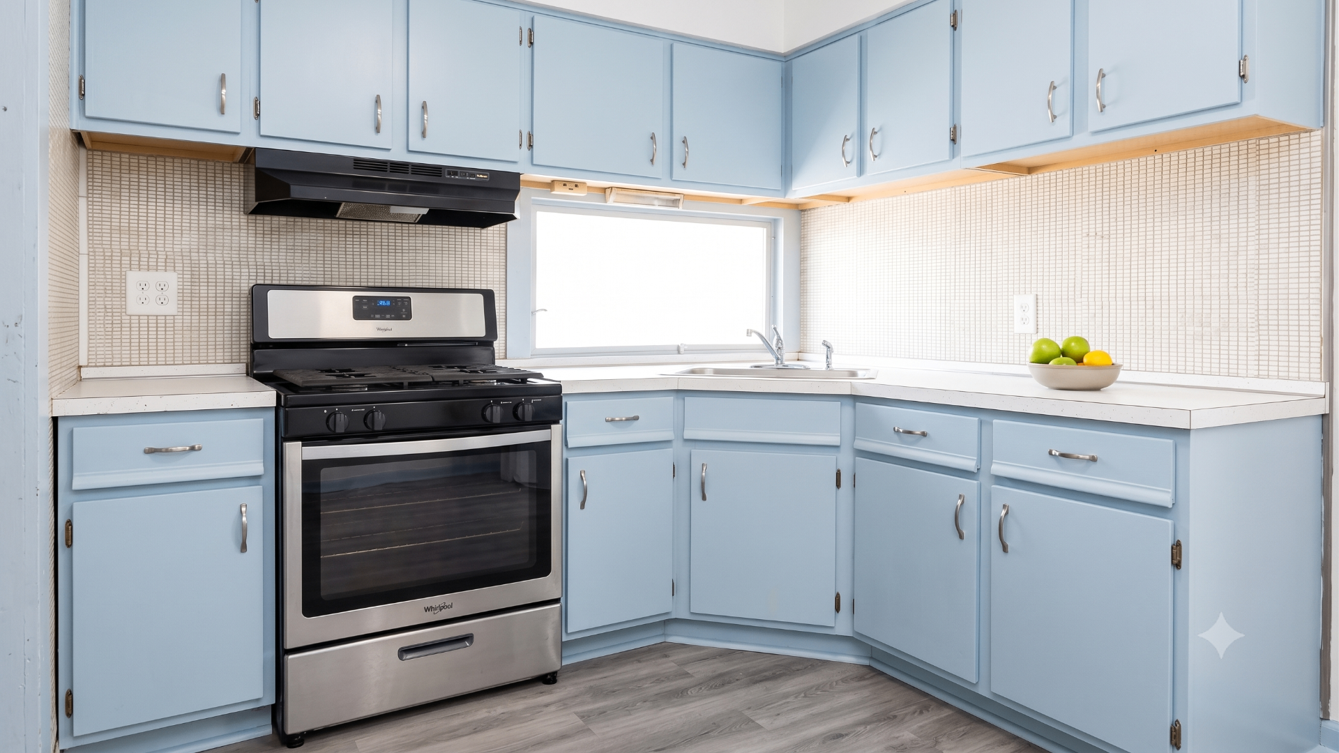Same kitchen after deep cleaning with refreshed blue cabinets, clean countertops and ready for the next tenant